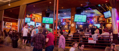 Lively bar scene in Uptown Dallas, with patrons enjoying drinks and socializing.