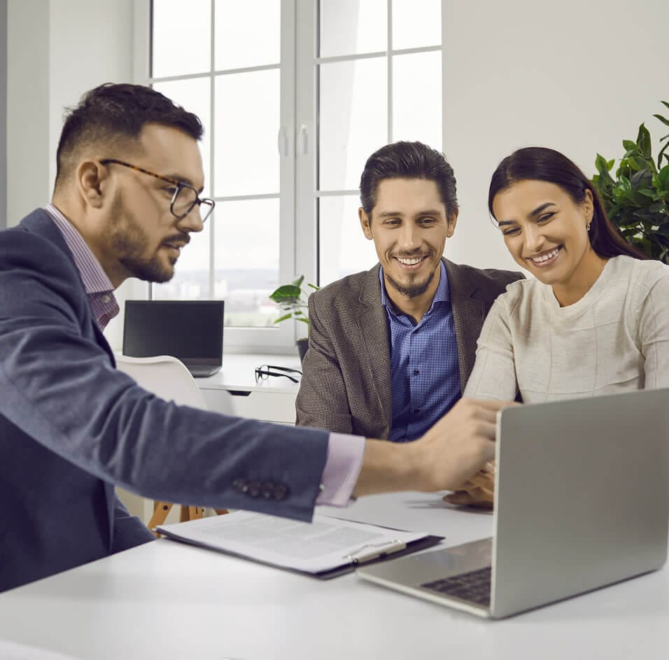 Business meeting with advisor and couple at laptop.